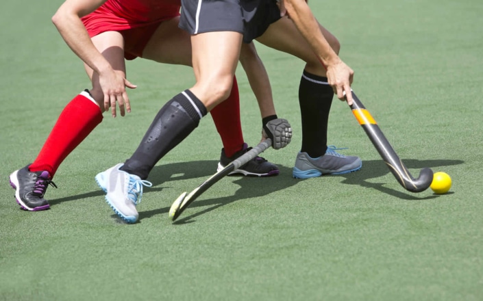 Hockey players from opposing teams both going for the ball