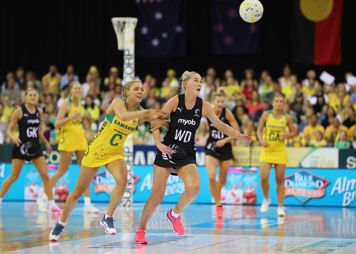 Professional netball players on a netball court.